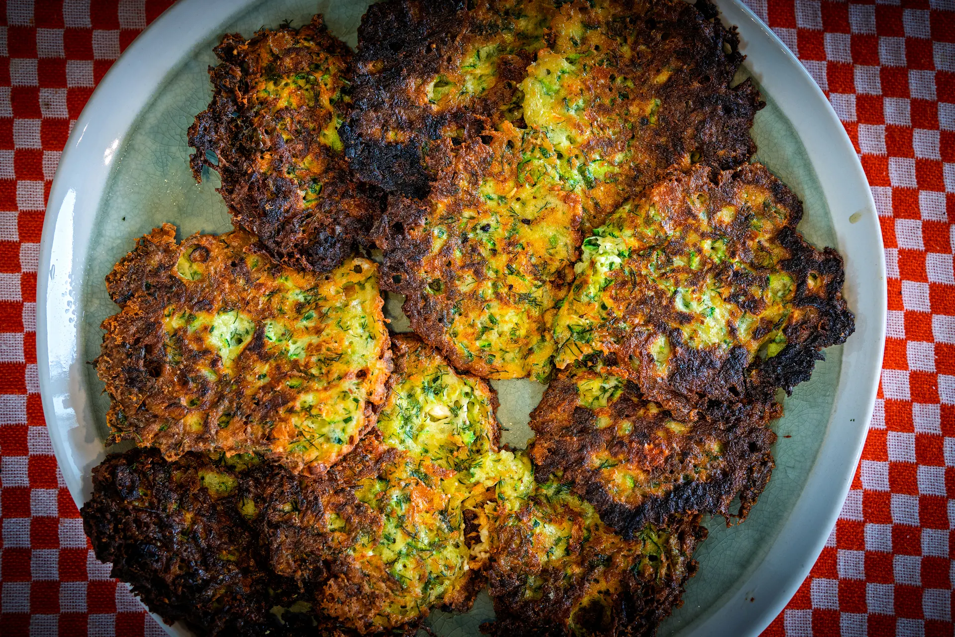 A plate of müçver, dark at the edges with dill through the middle.